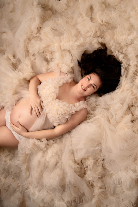 Babybauch-Shooting Unna Schwangere liegt auf dem Rücken im Kleid