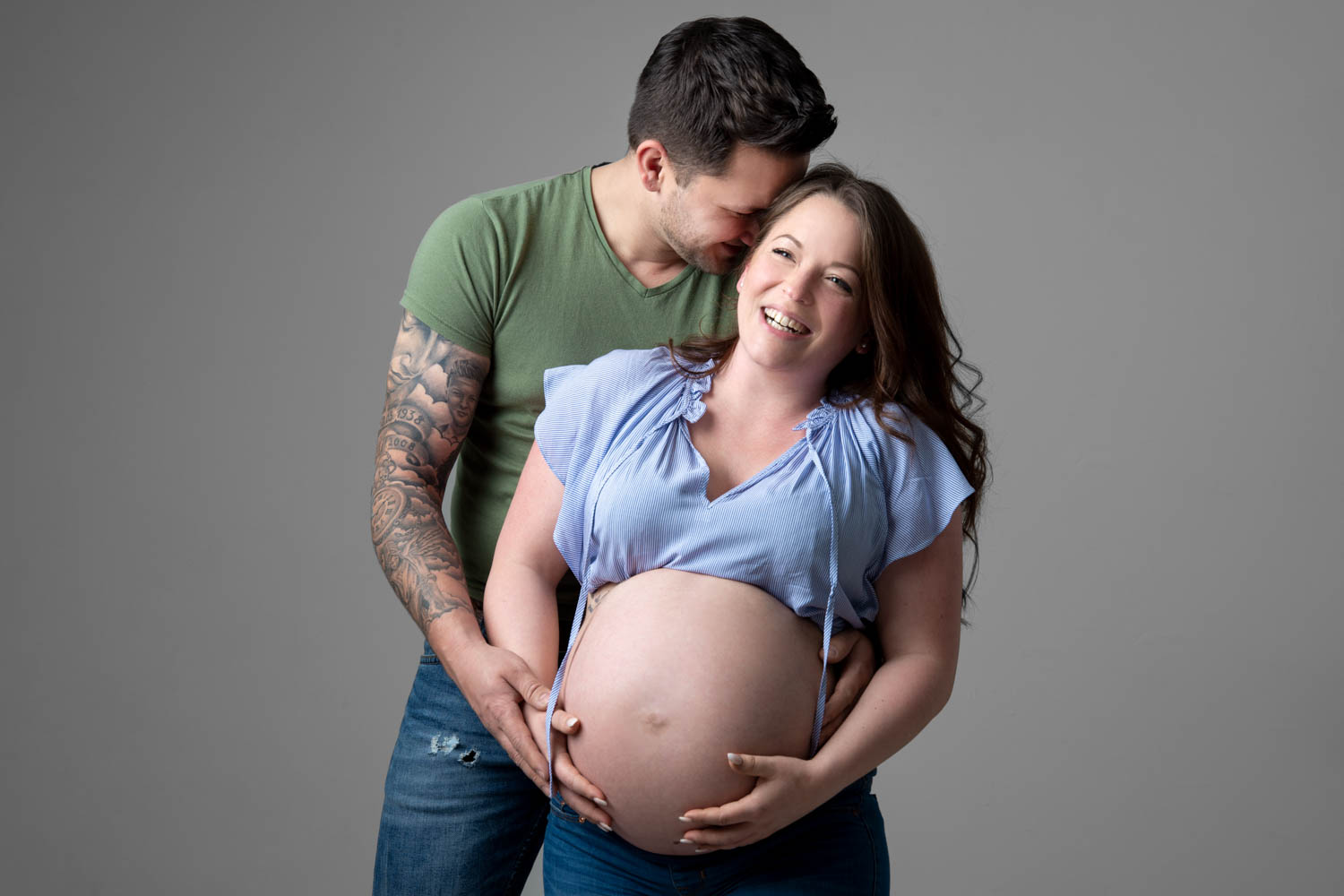 Babybauch-Shooting Mann umarmt Frau mit Babybauch