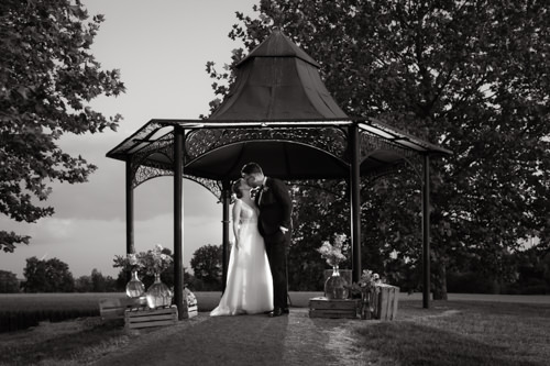 Hochzeitspaar küsst sich im Pavillion auf Gut Kump