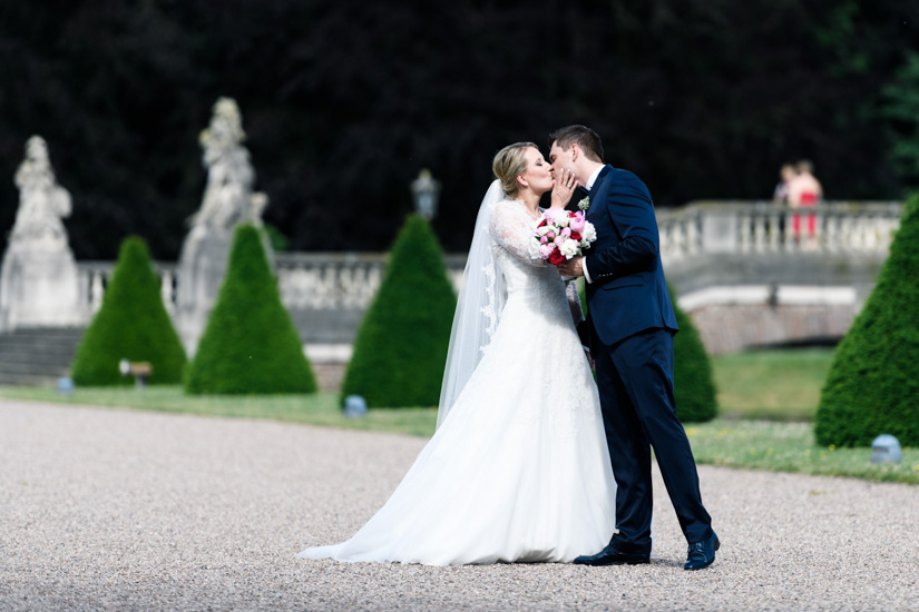 Braut küsst Bräutigam im Park von Schloss Nordkirchen