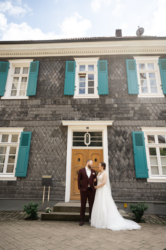 Brautpaar steht vor historischem Haus im Nicolaiviertel