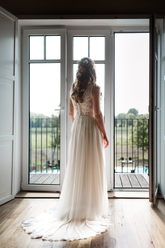 Hochzeitsfotograf-Münster-Braut steht vor Fenster
