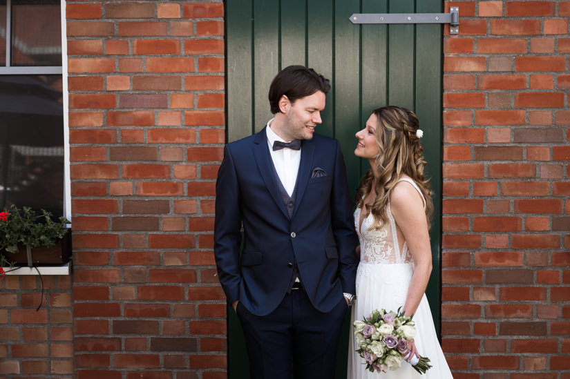 Braut und Bräutigam vor einer grünen Tür