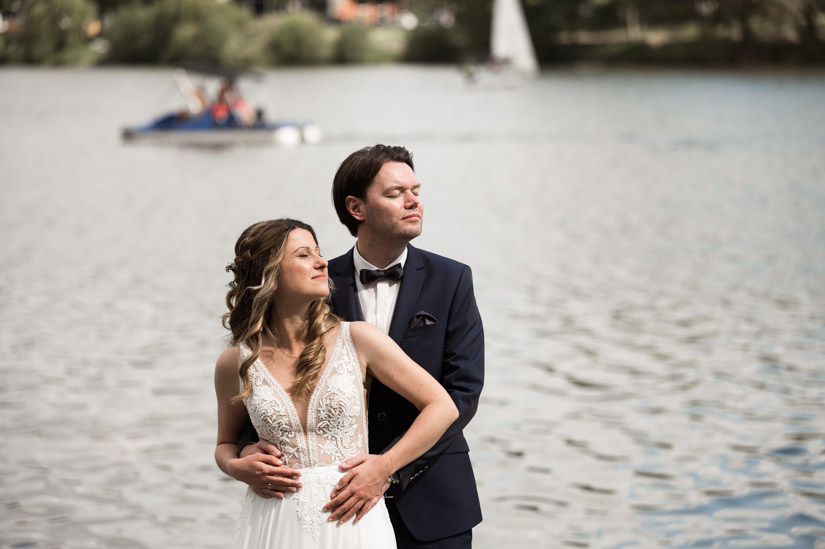 Das Hochzeitspaar steht am Ufer des Aasees in Münster