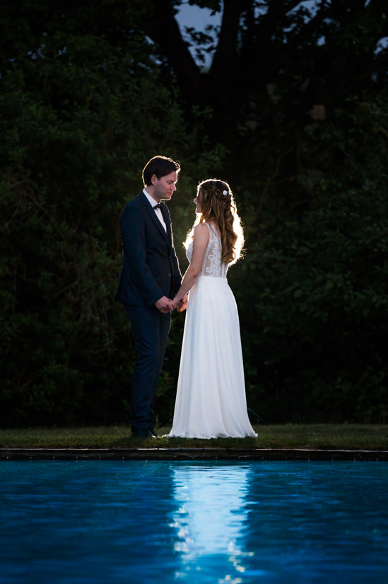 Hochzeitspaar steht am Pool vom Hotel Beverland in Münster